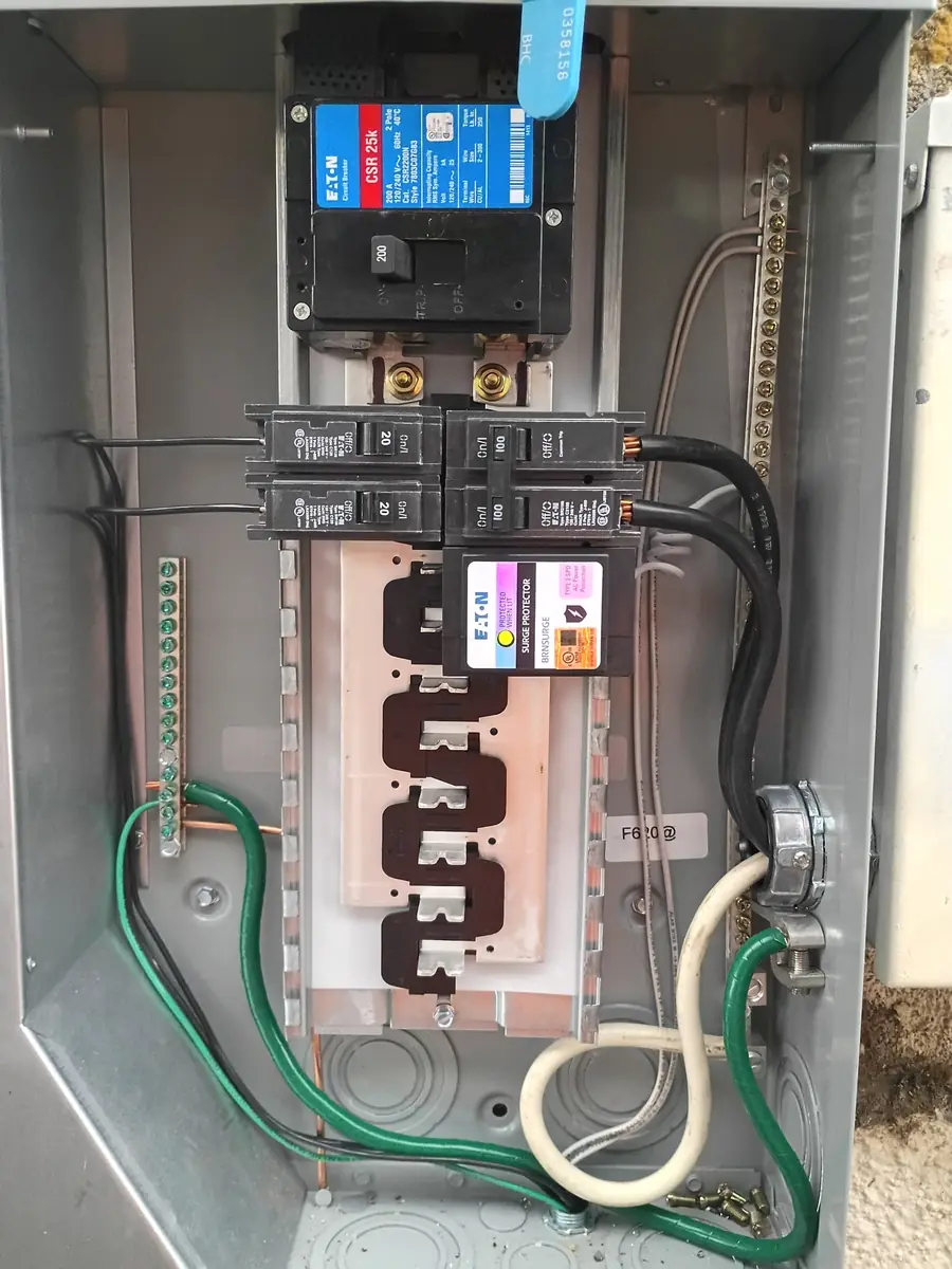 Eaton 200 amp meter-main with two 100 amp feeder breakers and a whole-home surge protector