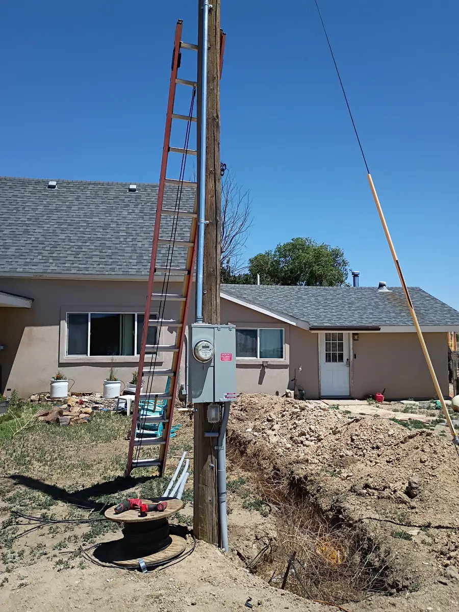 New meter pole with emergency disconnect and underground service trench to a house in rural Colorado